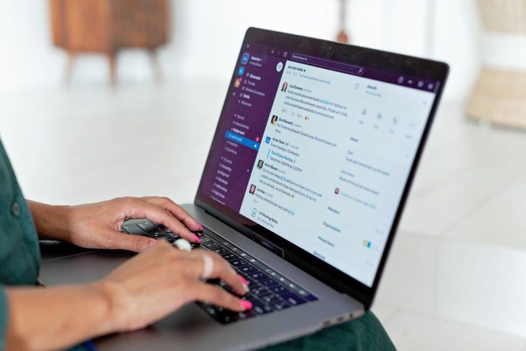 Close-up of hands typing on a laptop at home