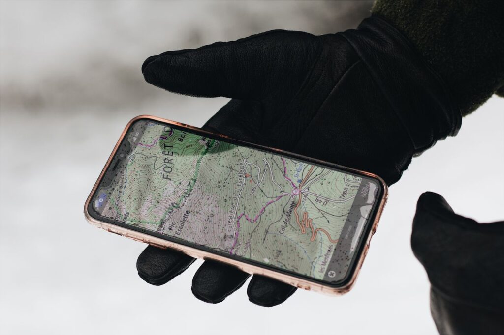 Gloved hand holding a smartphone with a map app