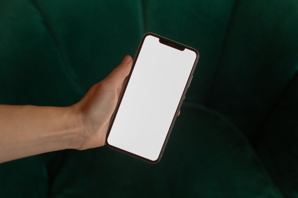 Hand holding a smartphone with a blank screen