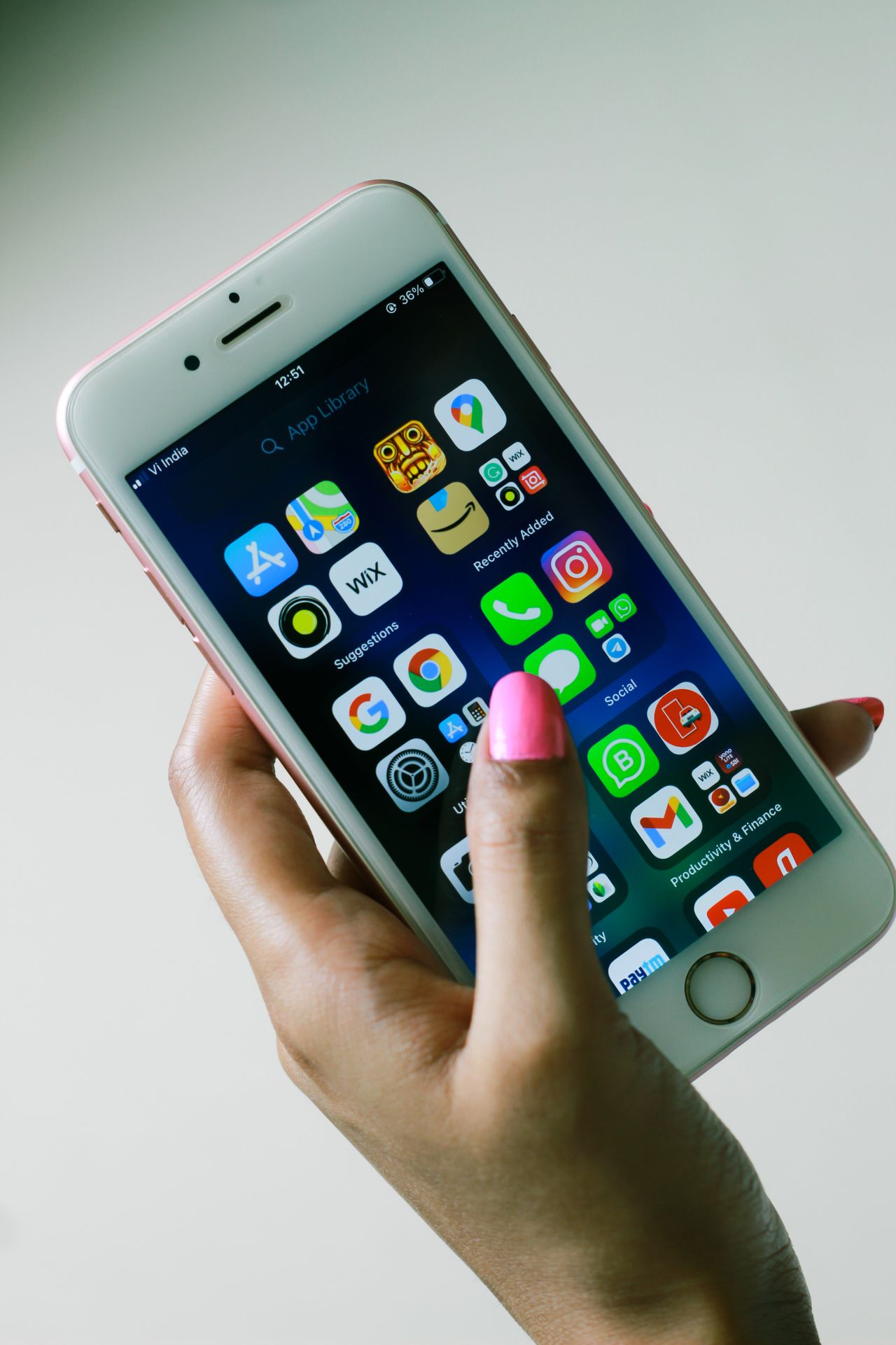 Hand holding a smartphone with apps on the screen