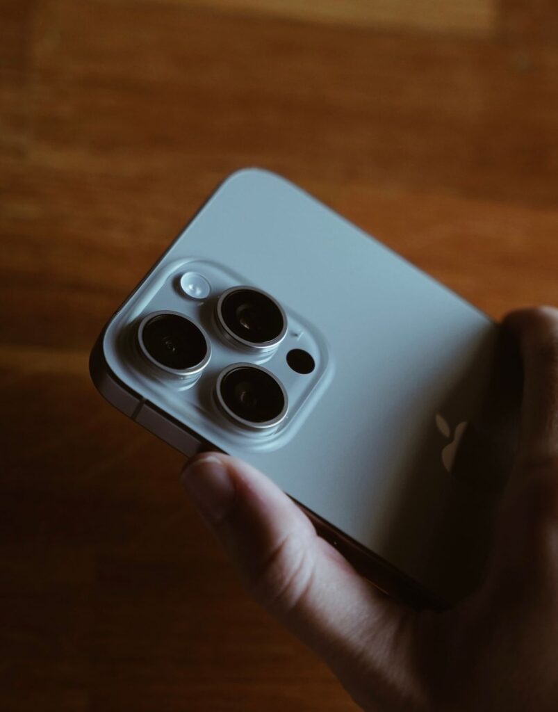 Hand holding a smartphone with triple cameras