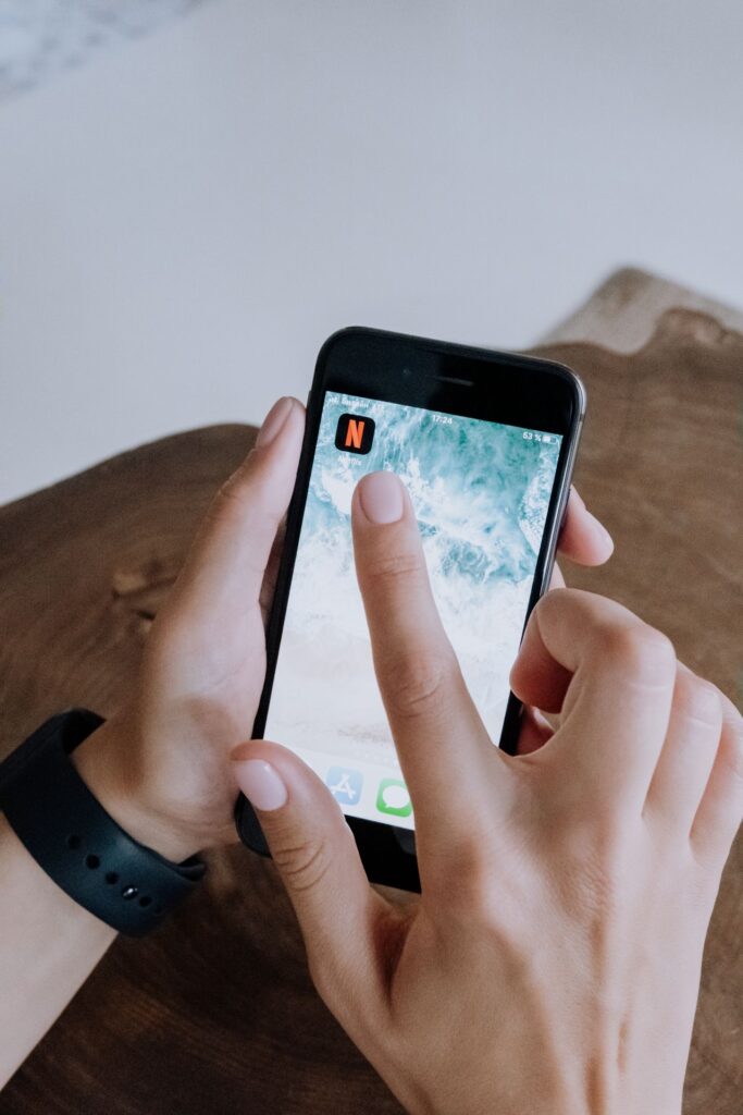 Hands using a smartphone app on a wooden table
