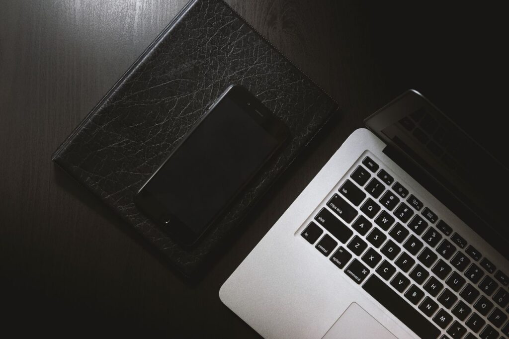 Laptop and smartphone setup on a black desk