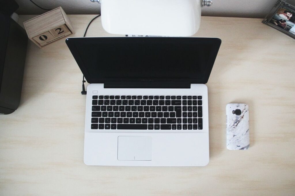 Laptop beside a smartphone on a minimalist desk