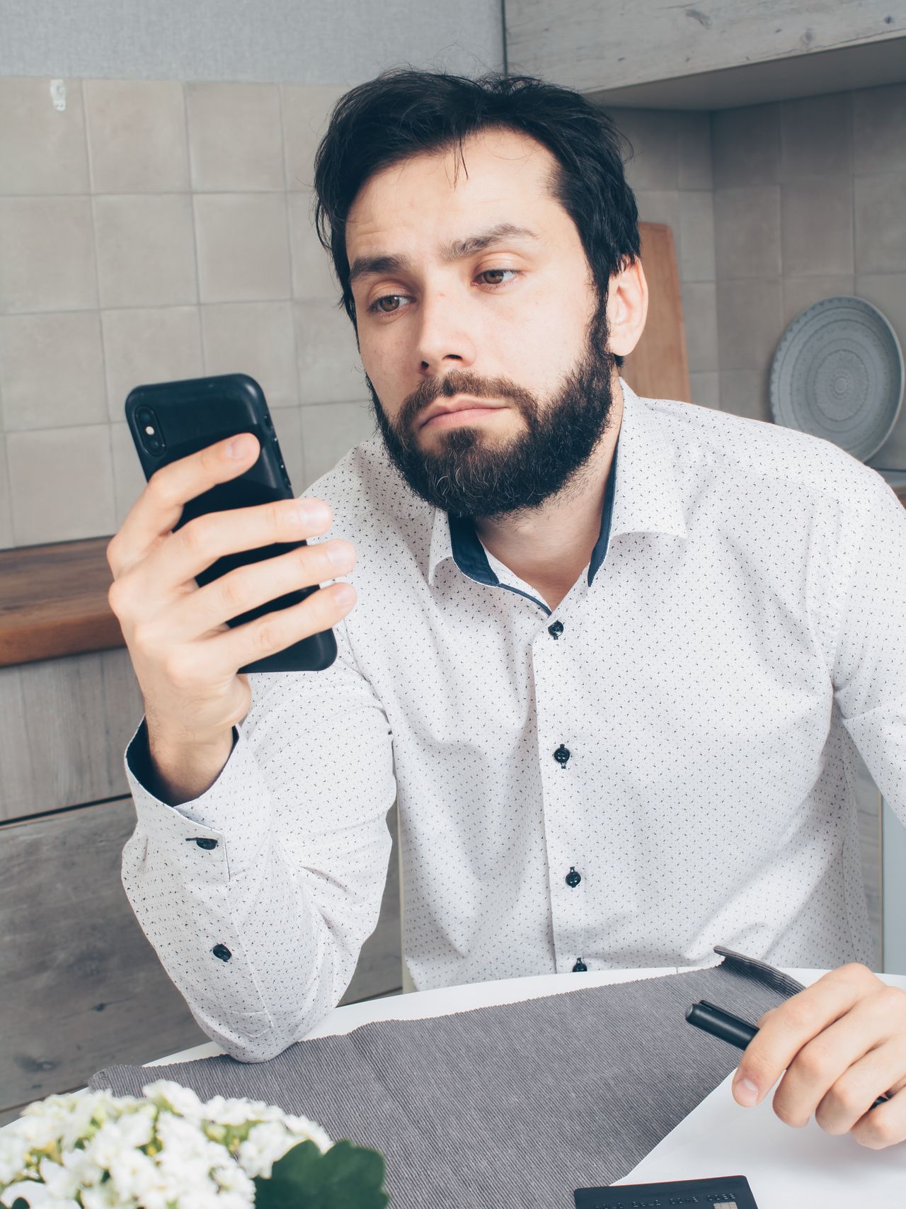Man looking worried while checking a message on his smartphone