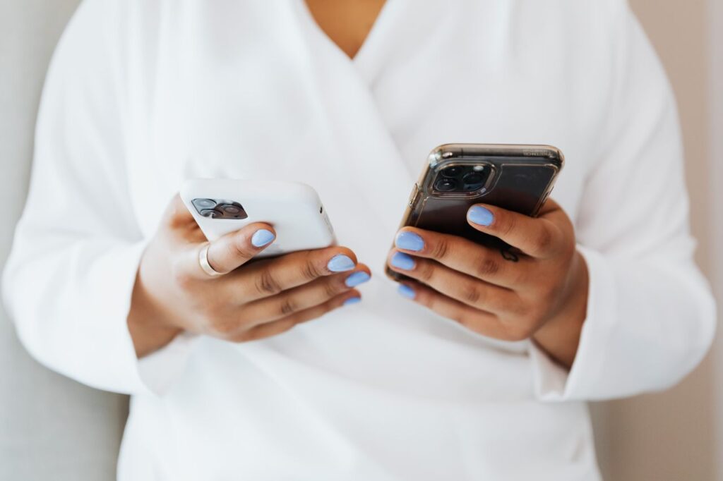 Person holding two smartphones