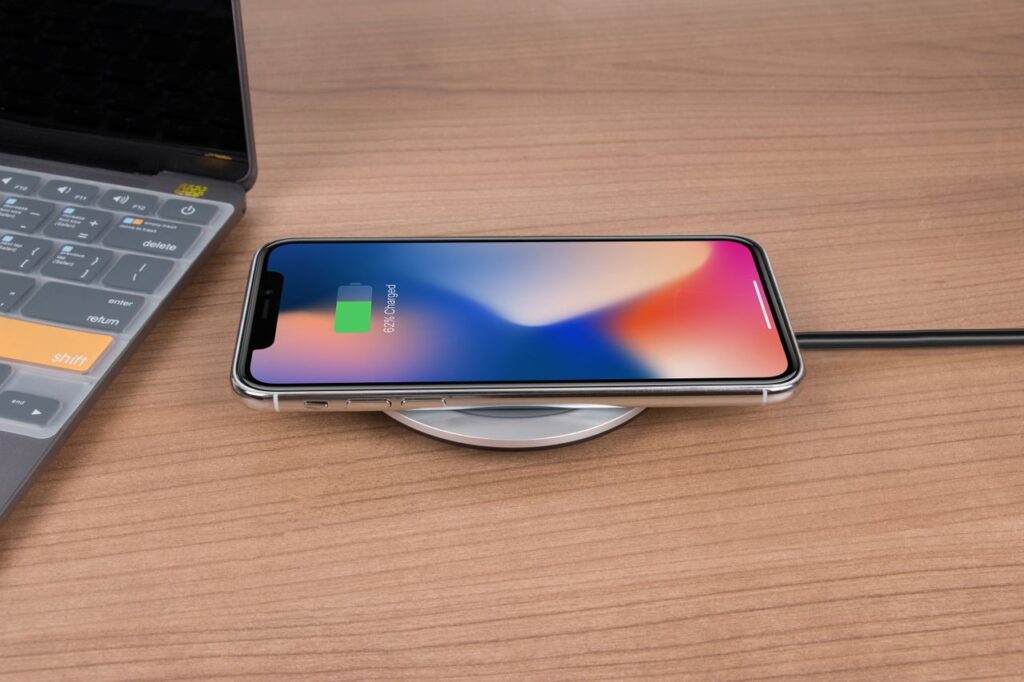Phone charging wirelessly next to a laptop