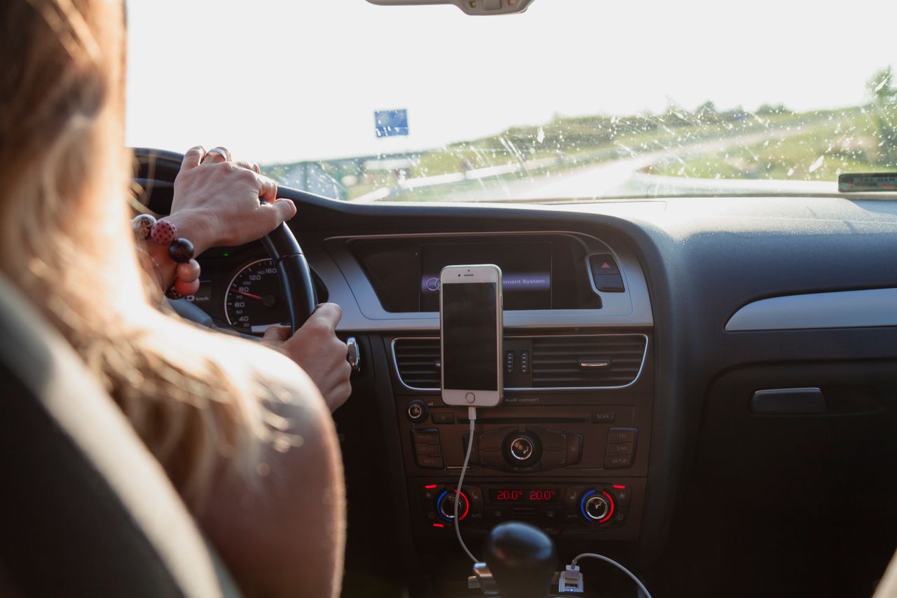 Phone mounted on a car dashboard on a sunny day