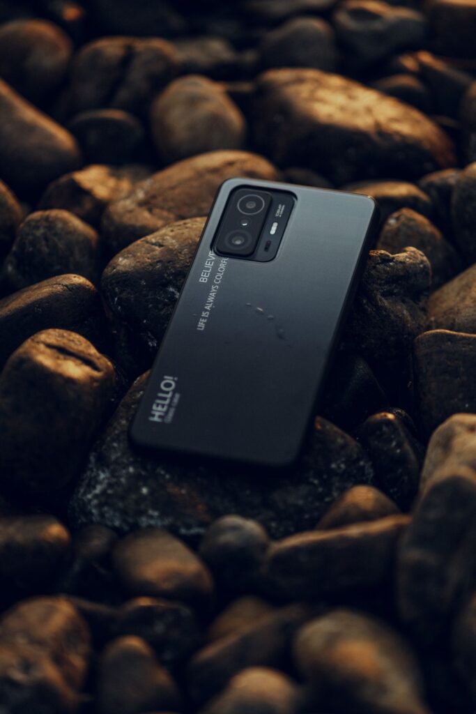 Smartphone resting on smooth beach stones