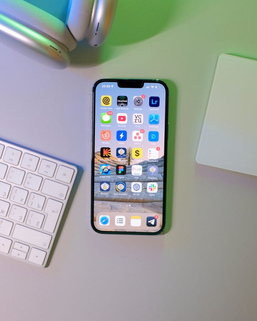 Smartphone with app icons lying on a desk next to a keyboard