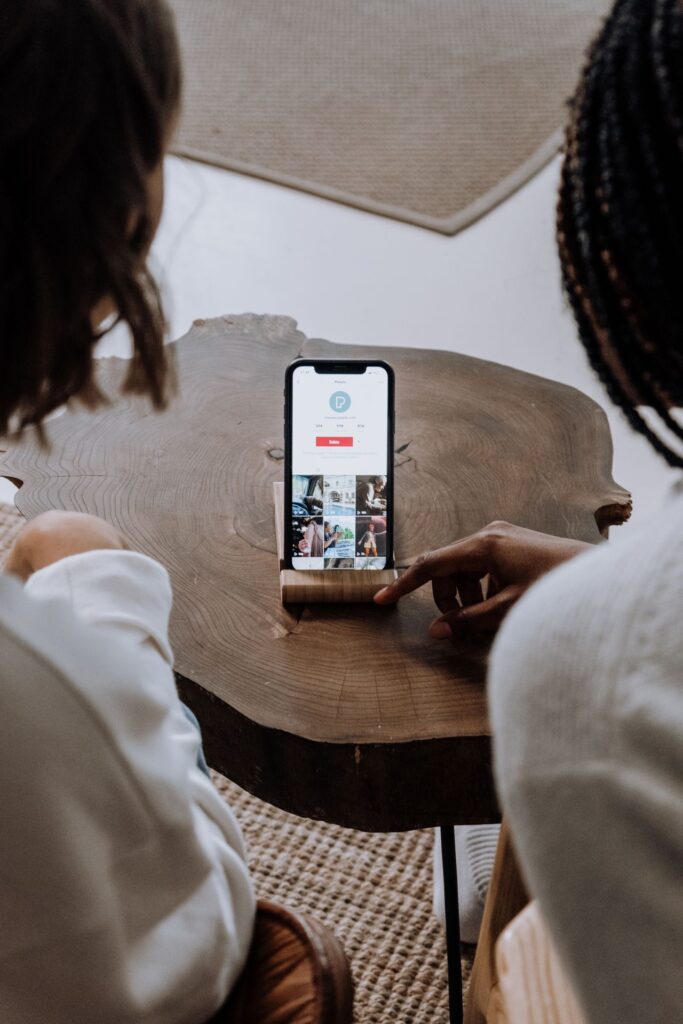 Two people looking at photos on a smartphone at a table