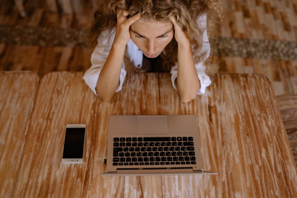 Woman looking stressed in front of a laptop